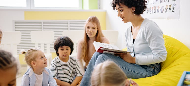 a teacher reading something to a bunch of small children whose parents opted for raising a family in Fort Belvoir VA