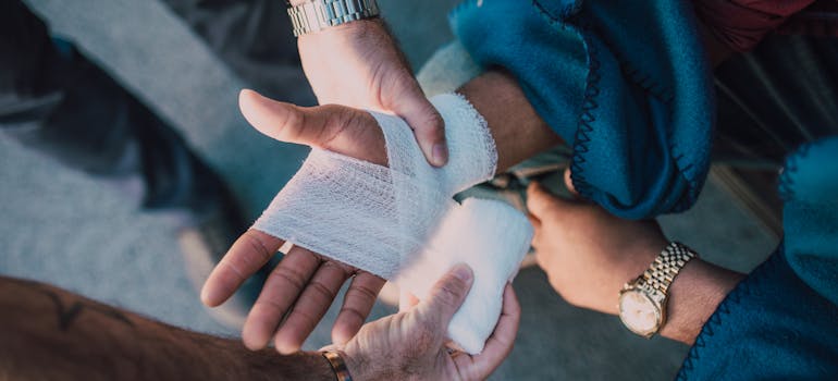 a person putting a bandage on another person's hand