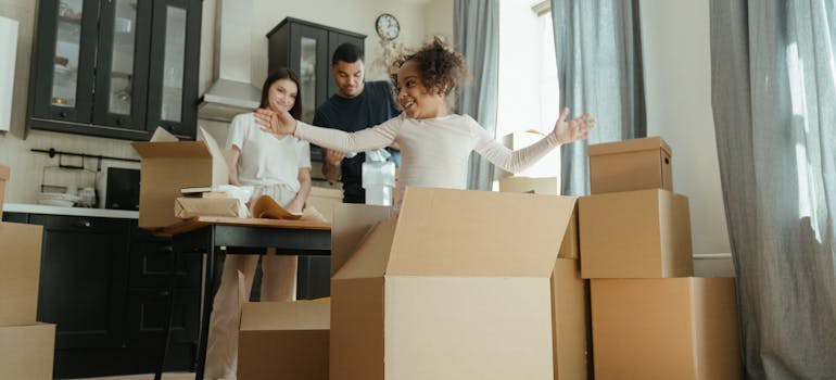 a family surrounded by cardboard boxes in their kitchen