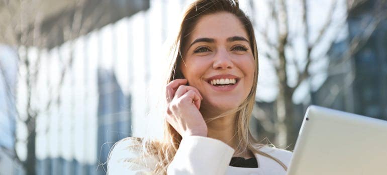 a woman on the phone with a smile on her face, as if she received some good news