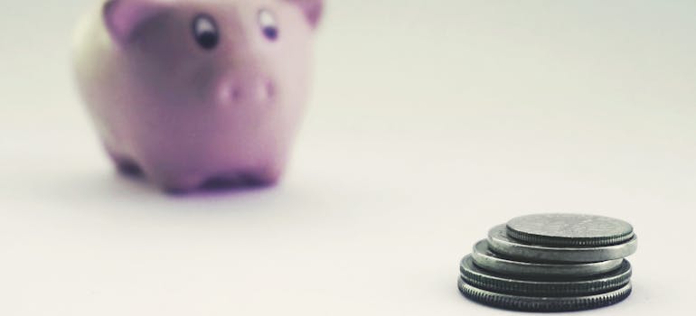 a pink piggy bank and some coins next to it